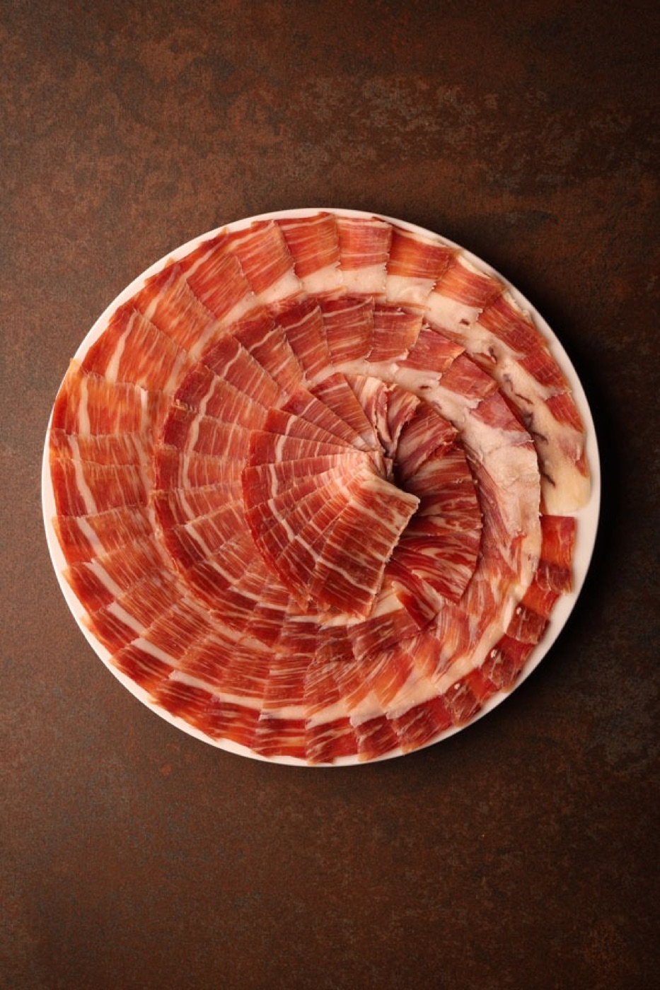 Plato de jamón ibérico emplatado en flor, listo para servir